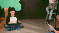 Middle school student reading script in theater class