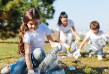 Photo of elementary students cleaning up garbage in park